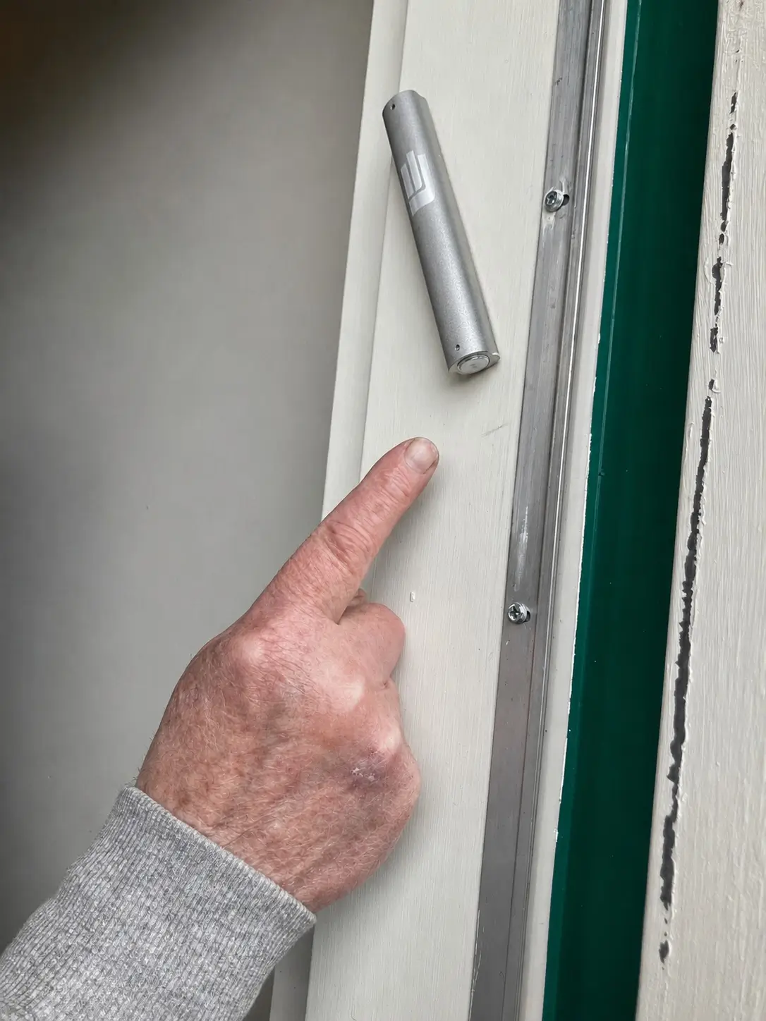 Sofer checking a mezuzah klaf under magnification during a house call